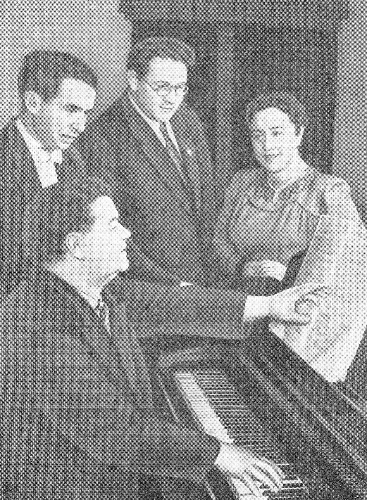 Г.К. Пукст знакомит с клавиром детской оперы "Марынка" дирижера И. Абрамиса, режиссера О. Моралева и автора либретто Э. Огнецвет. Источник иллюстрации: Г. К. Пукст, заслуженный деятель искусств БССР : очерк жизни и творчества / Д. Журавлев. – Минск, 1963. – С. 37.