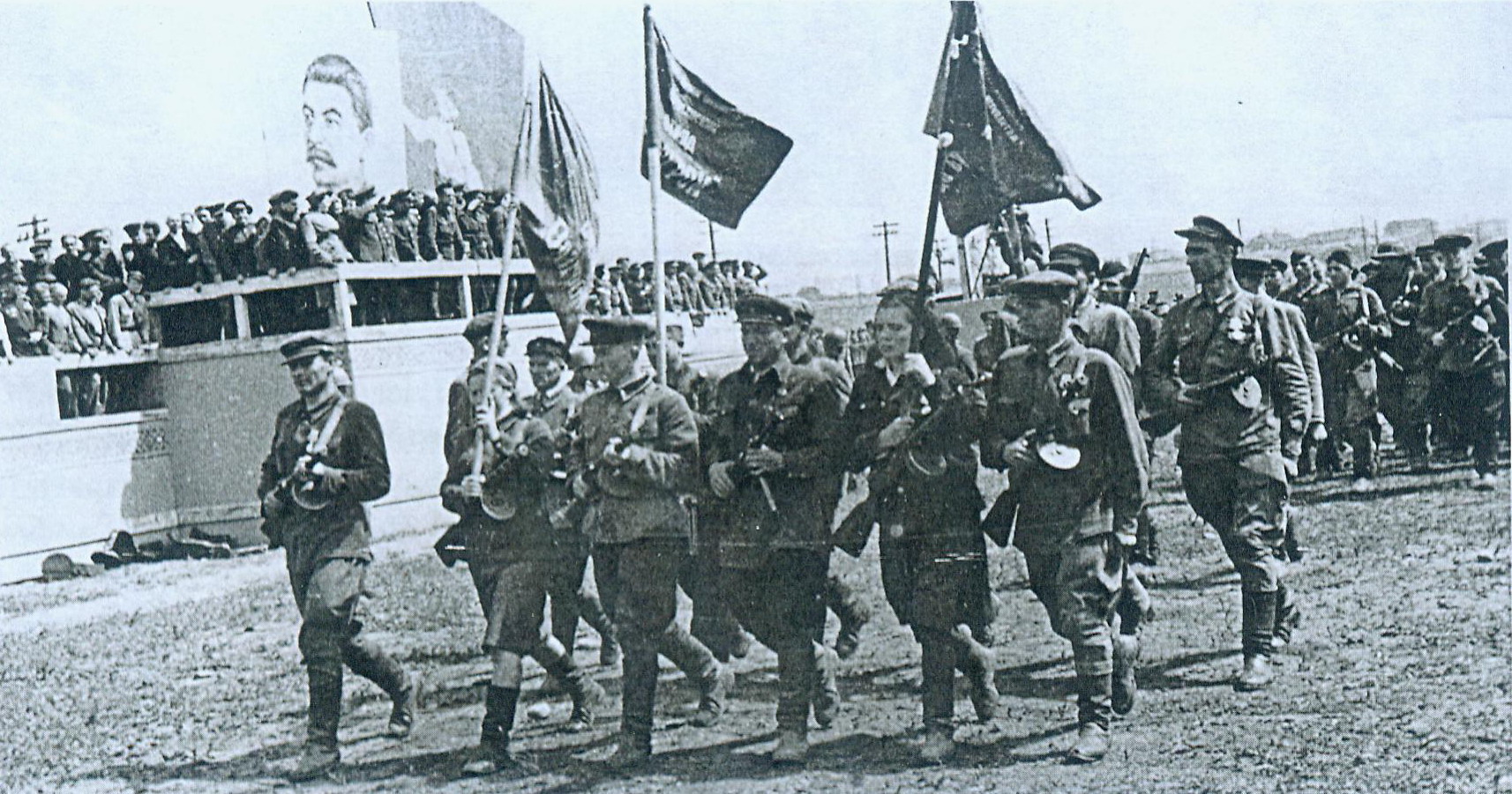 Партизанский парад. Впереди – знаменная группа. Источник иллюстрации: Освобождение Беларуси : хроника, события, герои, 1943–1944 гг. / Министерство культуры Республики Беларусь, Белорусский государственный музей истории Великой Отечественной войны ; [составители: Н. Д. Шевченко, В. П. Фалецкий ; редакционный совет: А. В. Галинская и др.]. – Минск, 2014. – С. 276.