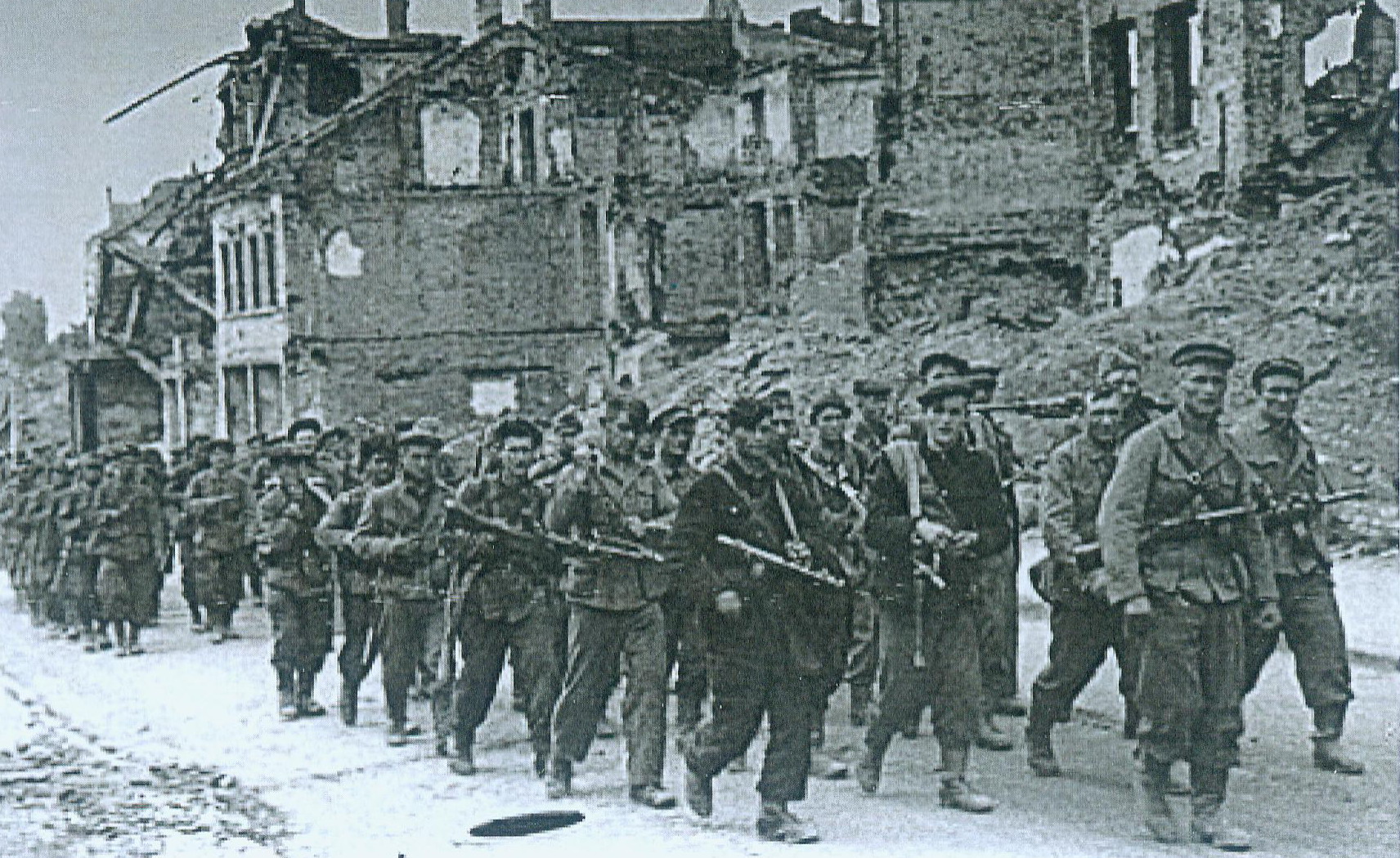 Партизаны входят в Минск для участия в параде. Источник иллюстрации: Освобождение Беларуси : хроника, события, герои, 1943–1944 гг. / Министерство культуры Республики Беларусь, Белорусский государственный музей истории Великой Отечественной войны ; [составители: Н. Д. Шевченко, В. П. Фалецкий ; редакционный совет: А. В. Галинская и др.]. – Минск, 2014. – С. 269.