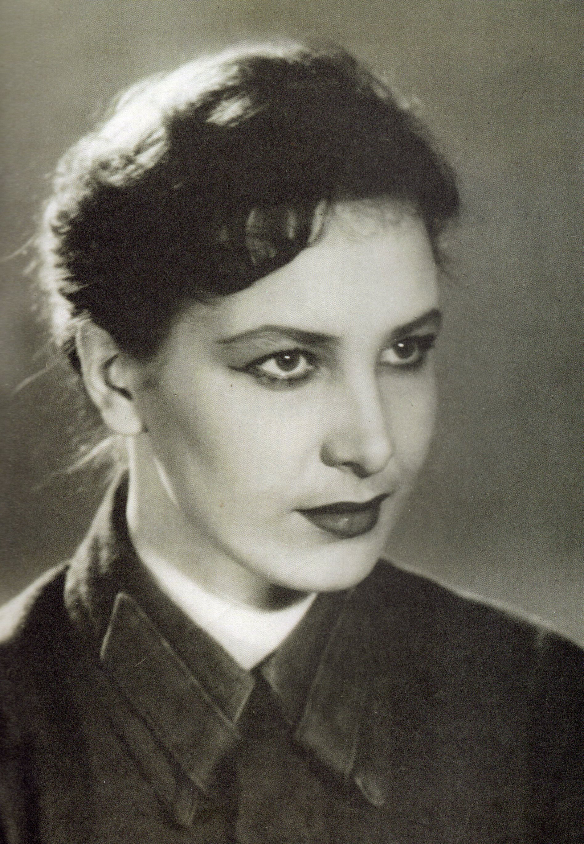 Марыя Захарэвіч у ролі машыністкі Шуры ў спектаклі "Рускія людзі" па п'есе К. Сіманава (1963). Крыніца ілюстрацыі: Марыя Захарэвіч. Талент, адухоўлены любоўю : успаміны, інтэрв'ю, прысвячэнні / [укладанне С. Жыбулеўскай]. – Мінск, 2016. – С. 7 уклейкі паміж с. 32–33.