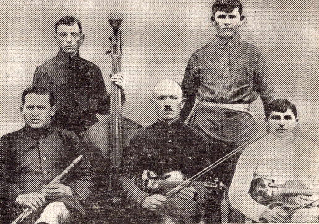 Адам Русак (у першым радзе першы справа) сярод вясковых музыкантаў в. Пясочнае (1920). Крыніца ілюстрацыі: Жыццё песні / І. К. Цішчанка ; рэдактар Г. І. Цітовіч ; Акадэмія навук Беларускай ССР, Інстытут мастацтвазнаўства, этнаграфіі і фальклору. – Мінск, 1984. – С. 20.