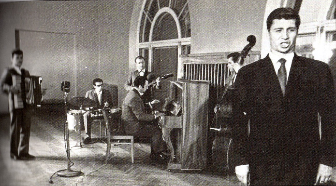 Виктор Вуячич (на переднем плане) и аккомпанирующий ансамбль: Измаил Капланов (аккордеон), Марк Шмелькин (ударные), Лев Моллер (фортепиано), Анатолий Шепелев (гитара), Ярослав Маркуц (контрабас). (Белгосфилармония, октябрь 1966 г.). Источник иллюстрации: Белорусская эстрада. Ностальгический дивертисмент : история эстрады Белорусской  государственной филармонии, 1930–1980-е годы / Ольга Брилон. – Минск, 2021. – С. 365.